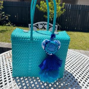 Teal weaved purse with tassel.